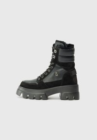 Des bottes montantes noires présentent une tige textur�ée, des œillets métalliques et une semelle en caoutchouc épaisse, conçues pour la durabilité et le style.