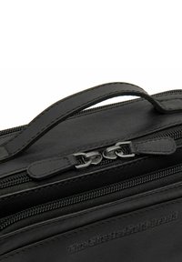 Borsa in pelle nera con manico superiore, dotata di hardware in metallo per la cerniera e texture liscia, impressa con il logo "The Chesterfield Brand".