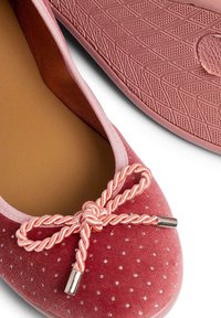 Ballerina in suede rosa con un interno liscio, adornata da un fiocco rosa attorcigliato e pois argentati, dotata di una suola in gomma pattern.
