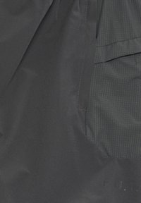 Ciemnoszary materiał o gładkiej teksturze, z kieszenią w wzory z cienkimi, kontrastującymi liniami i wytłoczonym napisem "F.U.T."