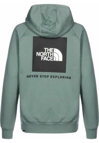 Felpa con cappuccio in tessuto verde chiaro con un logo quadrato nero che presenta la scritta "THE NORTH FACE" e il testo "NEVER STOP EXPLORING" sottostante.
