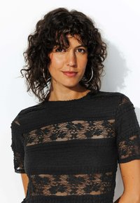 Haut noir en tissu texturé avec des panneaux en dentelle horizontaux, manches courtes et encolure ronde. Fini lisse avec des détails en dentelle florale.
