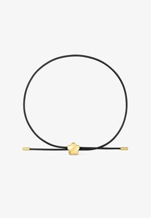 Collana con cordoncino nero e un piccolo ciondolo a forma di fiore in oro al centro, con punte in oro alle estremità del cordoncino.