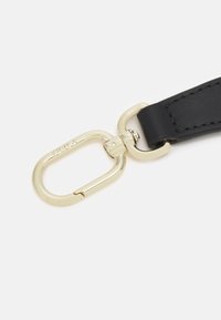 Černý kožený pásek s karabinou z pozlaceného kovu, který se vyznačuje hladkým povrchem a detailním prošíváním.