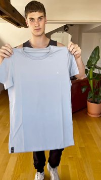 Svijetloplavi pamučni majica kratkih rukava s okruglim izrezom; sadrži mali logotip na lijevoj strani prsnog koša i oznaku na donjem lijevom dijelu.