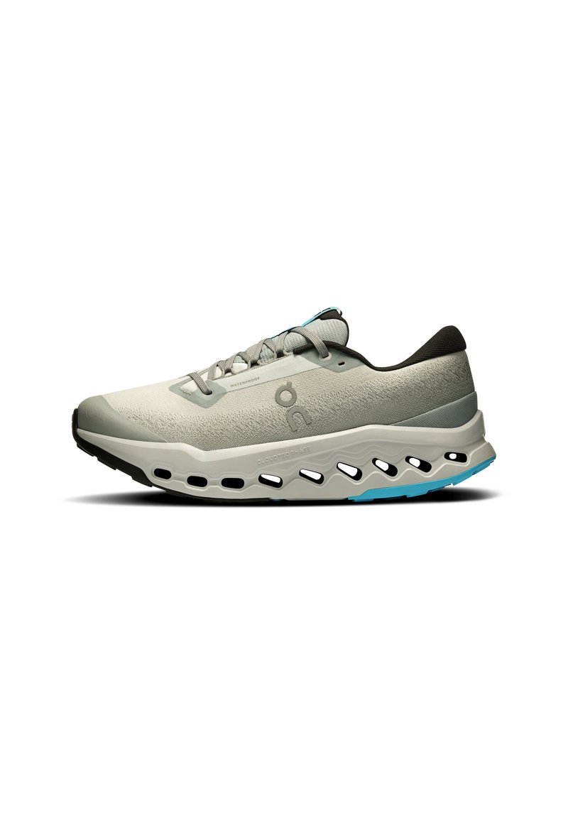 Hellgraue Laufschuhe mit einem strukturierten Mesh-Obermaterial, schwarzen Akzenten und blauen Details. Verfügt über eine dicke Sohle mit Ausschnitten zur Belüftung.