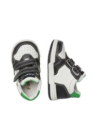 Sneaker bianco e nero con dettagli verdi, dotati di perforazioni, due fasce in velcro e suola in gomma texturizzata per una migliore aderenza.