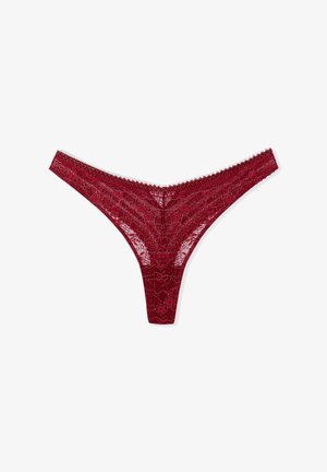 Perizoma rosso in pizzo con motivo floreale, bordi ondulati e texture liscia; presenta una vita sottile e un design a copertura minima.