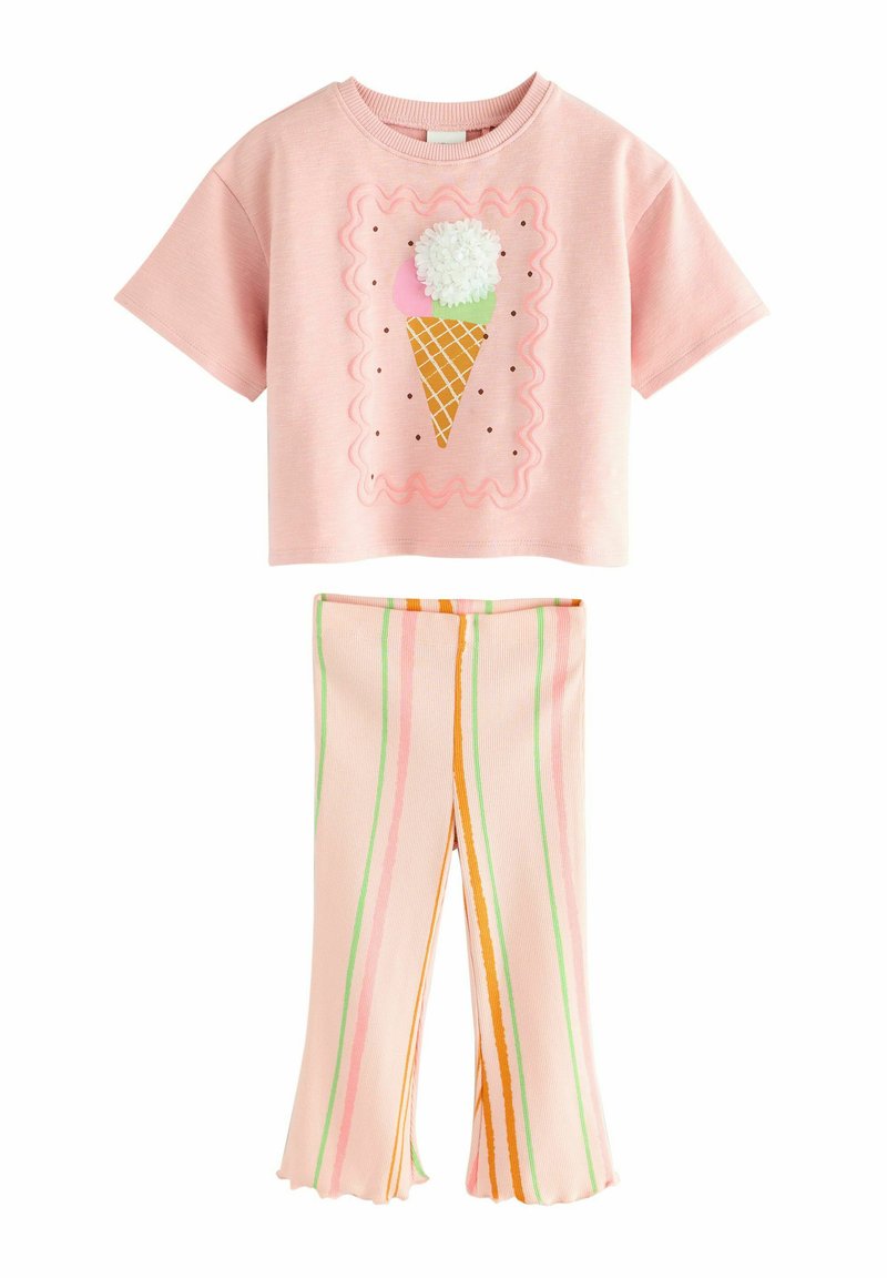 T-shirt cropped rose avec un graphique de cône de glace. Pantalons évasés à rayures dans des couleurs pastel avec des lignes vertes, roses et orange.