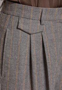 Grijze wollen broek met oranje verticale strepen, voorzien van plooien en een gestructureerde tailleband met een spitse flap.