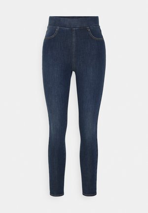 Tummansiniset denim-jeggingsit, joissa on korkea vyötärö, kapea istuvuus ja hillitty kuluminen. Sisältää etutaskut ja sileän, pehmeän tekstuurin.