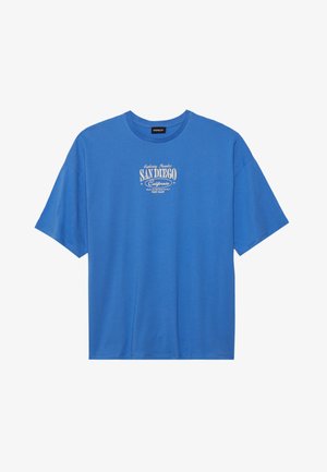 T-shirt de algodão azul com mangas curtas. Apresenta uma impressão gráfica em branco com o texto "San Diego, Califórnia" centrado no peito.
