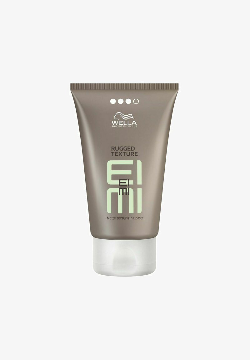 Bruine knijptube met matte afwerking, groene tekst en logo; gelabeld "Rugged Texture EIMI Matte Texturizing Paste" aan de voorkant.
