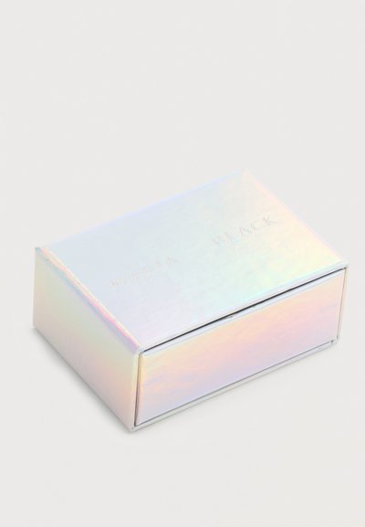 Ορθογώνιο ιριδίζον κουτί με διακριτικό ανάγλυφο κείμενο «Maria Black» στην πάνω επιφάνεια, τοποθετημένο σε μια απλή ανοιχτόχρωμη επιφάνεια.