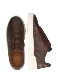 Zapatillas de piel marrón tipo slip-on con un acabado texturizado, diseño de cordones elásticos y suelas de goma blancas. Presentan un perfil bajo y punta redondeada.