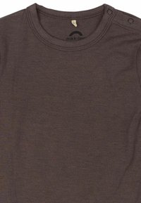 Camisa de algodón marrón de manga larga con cuello redondo acanalado, que cuenta con botones a presión en el hombro y una pequeña etiqueta dentro.