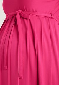 Heißpinkes Kleid mit gebundener Taillendetail, das plissierten Stoff und eine glatte Textur aufweist. Der Ausschnitt ist rund und schlicht gestaltet.