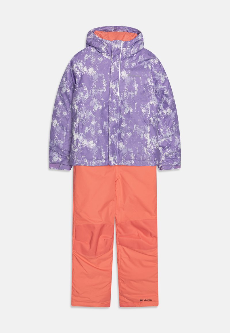 Lilla og hvid mønstret isoleret jakke med hætte over orange isolerede bukser. Begge lavet af syntetiske materialer og med kontrasterende farver.