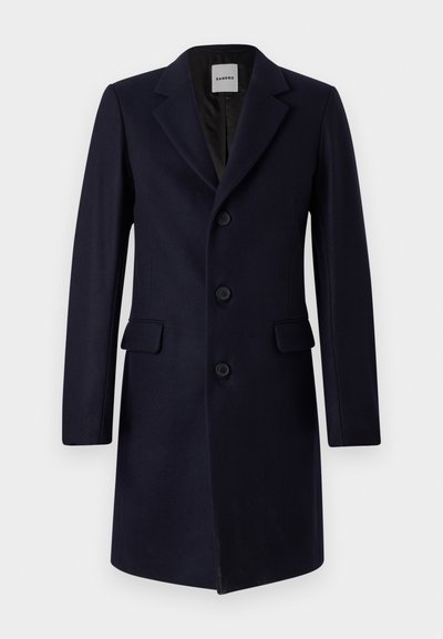 Cappotto in misto lana navy con design strutturato, rever a punta, tre bottoni e due tasche anteriori. Texture liscia e vestibilità su misura.