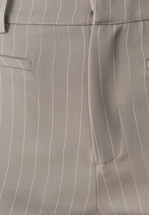 Beige kangas na vertical white pinstripes; inaonyesha mifuko ya upande na muundo uliosafishwa, ikionyesha uso laini na wenye muundo.