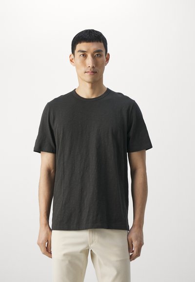 Dark gray short-sleeve t-shirt made of soft fabric with a classic crew neck design, worn with light beige pants.