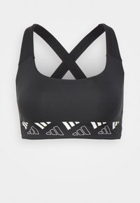 Top desportivo preto com alças cruzadas nas costas, apresentando um design recortado na parte inferior e acentos geométricos brancos. Textura suave, material elástico.