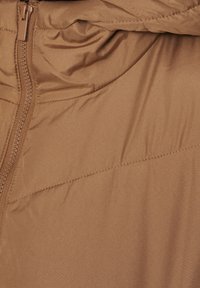 Brun puffjacka med en glatt, glänsande yta, som har en hel dragkedja och subtil sömnad över tyget.