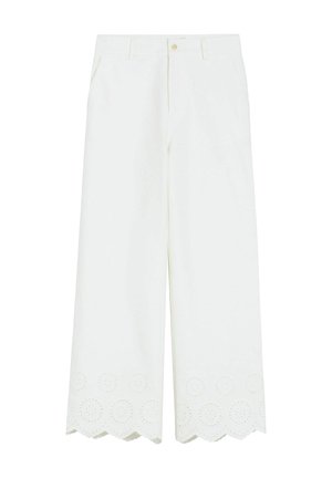Białe spodnie o szerokich nogawkach z falbaniastymi, ażurowo haftowanymi zakończeniami, przednimi kieszeniami oraz zapięciem na guzik w pasie.