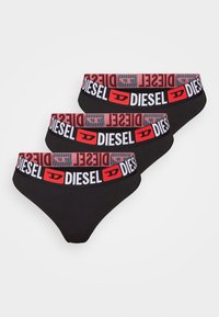 Ensemble de string noir avec ceinture élastique contrastante rouge et blanche arborant le logo "DIESEL". Trois paires exposées en rang.