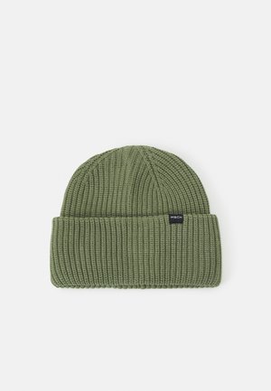 Bonnet vert en tricot avec bord replié et une petite étiquette noire indiquant "MSCH" à l'avant sur fond blanc.