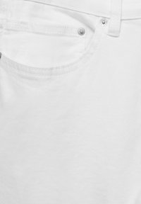 Witte denim jeans hebben een klassieke vijf-pocketontwerp, zilverkleurige hardware en een gladde, textuurvrije afwerking met zichtbare stikseldetails.