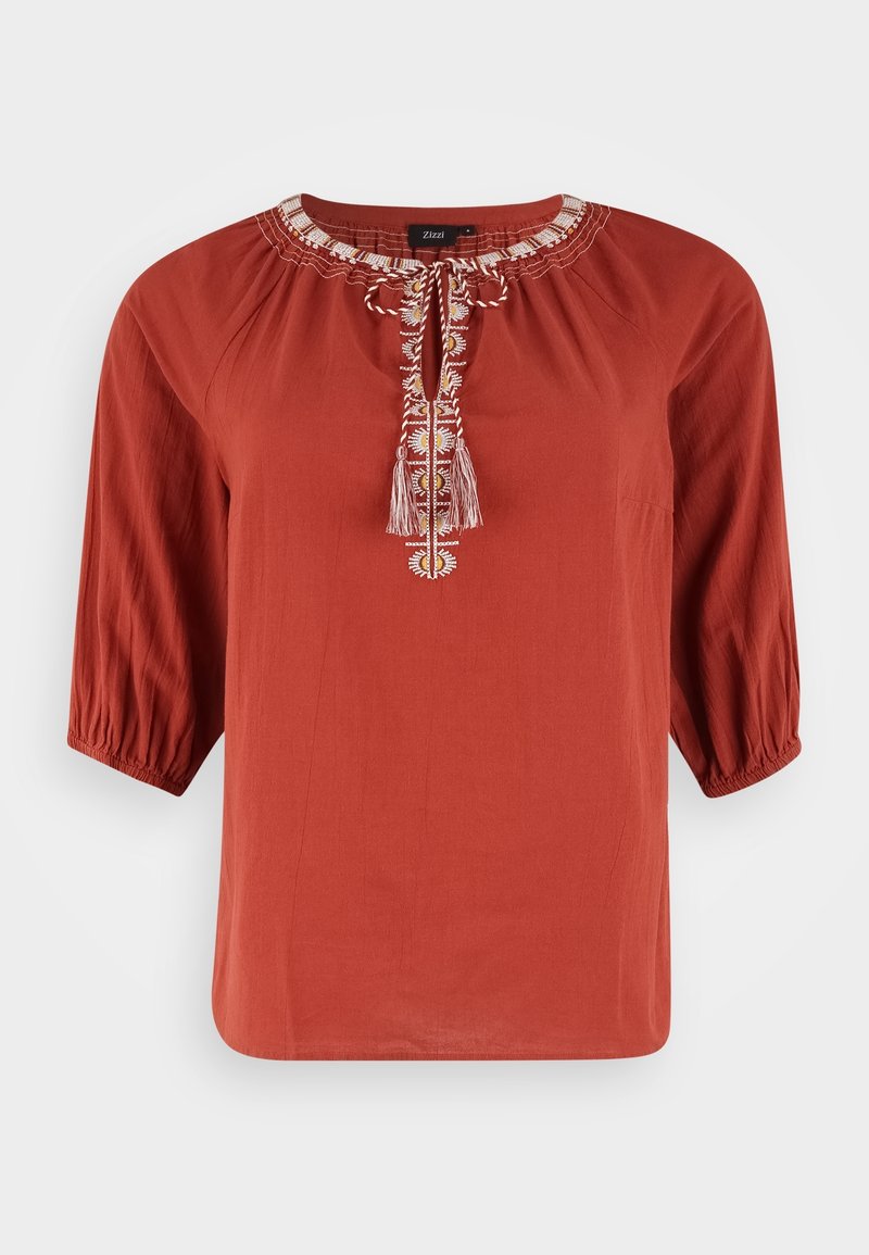 Chemise couleur rouille avec un col rond, des manches trois-quarts et des détails brodés à l'avant, ornée de pompons et dotée d'une coupe décontractée.