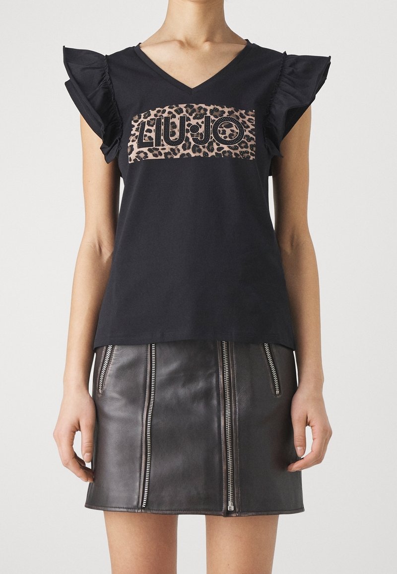 Camiseta de algodón negra con mangas acampanadas y un logotipo de leopardo "LIU JO" en el frente, combinada con una falda de cuero negra con cremallera.