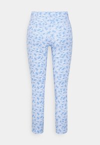 Ljust blå byxor med ett blommönster i vitt. Designen har en figursydd passform och en slät textur.