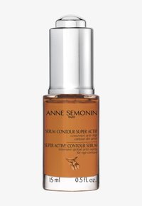 Botella de suero de vidrio ámbar con tapa de bomba plateada. La etiqueta presenta texto en negro sobre un fondo naranja. Capacidad: 15 ml (0,5 fl. oz.).