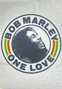 Bílý tričko s kruhovým designem, na kterém je černá silueta usmívajícího se muže, text "BOB MARLEY ONE LOVE" a akcenty v červené, žluté a zelené barvě.