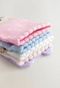 Une pile de chaussettes en tricot dans des couleurs pastel : rose à pois, bleu clair, blanc et violet clair, avec des motifs côtelés et texturés.
