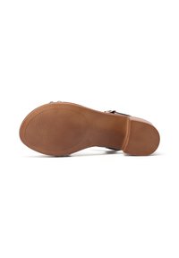 Soletta in gomma marrone chiaro con una superficie testurizzata e un piccolo tacco. Presenta una finitura liscia con una forma arrotondata e un logo discreto.