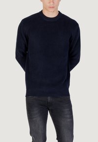 Maglione a coste di colore blu navy con scollo a girocollo e maniche lunghe, caratterizzato da una superficie testurizzata e un orlo dritto.