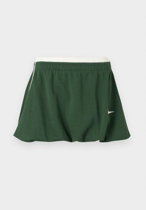 Σκούρα πράσινη αθλητική φούστα με λευκή ελαστική μέση και μικρό λευκό λογότυπο Nike στην πλευρά, εμφανίζεται σε λευκό φόντο.