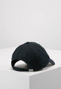 Zwarte katoenen baseballcap met een gebogen rand, geborduurd logodetail en een verstelbare band aan de achterkant. Gelaagd stof.