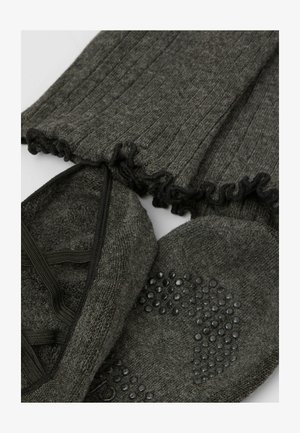 Grijze gebreide leggings met ruches aan de randen en een bijpassend paar sokachtige schoenen met een textuur en verbeterde grip aan de zool.