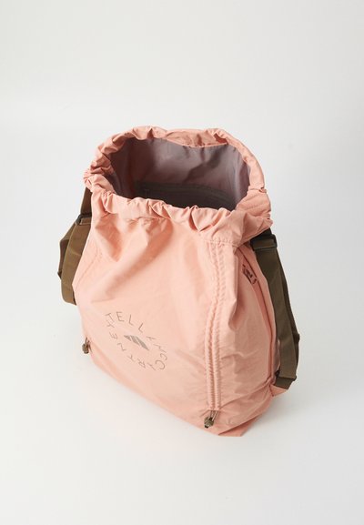 Rosa Nylon-Schnürbeutel mit einem runden Logo und braunen Trägern, mit einer gestrafften Öffnung und einer strukturierten Oberfläche.