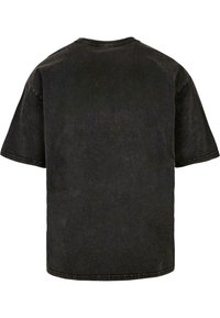 Schwarzes Baumwoll-T-Shirt mit lässiger Passform, kurzen Ärmeln, Rundhalsausschnitt und verblasster Textur. Detaillierte Naht am Halsausschnitt.