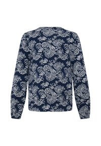 Chemise bleu marine à manches longues avec un motif floral blanc couvrant tout le tissu, vue de dos sur fond blanc.