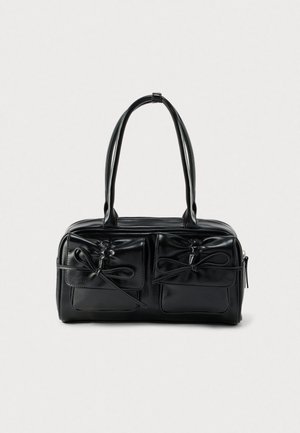 Fekete bőr válltáska két első zsebbel és masni díszítéssel, masszív fogantyúkkal és strukturált, téglalap alakú formával.