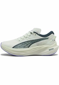 Scarpa da corsa bianca con tomaia in mesh testurizzato, dettagli in verde scuro e suola spessa viola. Presenta un design aerodinamico e dettagli con logo.