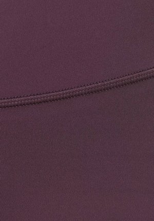 Close-up van donkerpaars stof met een zichtbare naad en strakke, gelijkmatige stiksels.