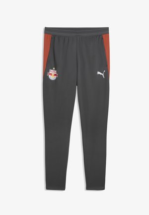 Pantaloni sportivi grigio scuro con pannelli laterali rossi, logo Red Bull Salzburg sulla coscia sinistra e logo Puma bianco sulla coscia destra.