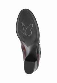 Semelle en caoutchouc noire avec grip texturé et logo en forme de papillon ; tige en cuir bordeaux avec détail de couture ; talon arrondi pour le soutien.